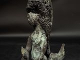 bronze sculpture of a woman sitting on the ground with her hands on her knees