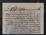 arabic writing on a piece of paper hanging in a window