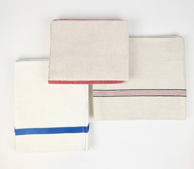 trois serviettes à rayures rouges, blanches et bleues sont empilées les unes sur les autres