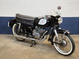 a black motorcycle parked in a garage with a blue wall