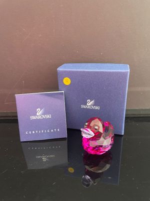 une boîte-cadeau violette ornée d'un cœur en verre rose et une boîte violette ornée d'un cœur rose