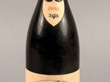 une bouteille de vin rouge posée sur une table, sur fond gris