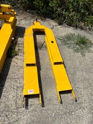 two pieces of yellow metal sitting on the ground next to a bush