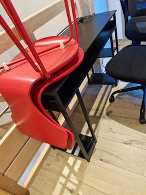 a red suitcase sitting on a chair next to a black chair