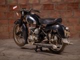 a black motorcycle parked in front of a brick wall