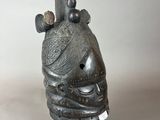 a close up of a statue of a head with a bird on it