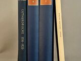 trois livres sont empilés sur une table