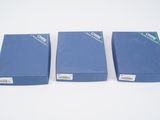 three blue boxes are lined up on a white surface