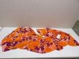 an orange and pink scarf sitting on top of a white table