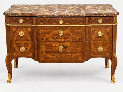 une commode ancienne avec un dessus en marbre et des poignées en laiton