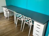 trois chaises et un bureau dans une pièce aux murs bleus