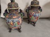 une paire de vases asiatiques ornés de motifs colorés, posés sur une table