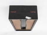 a black box with a knife in it on a white surface