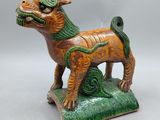 an image of a figurine of a dog on a green base