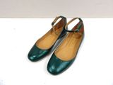 a pair of green shoes on a white surface