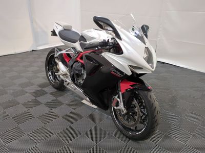 une moto blanche et rouge garée sur un sol à carreaux noirs