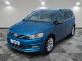 the blue volkswagen touran is parked in a room with a checkered floor