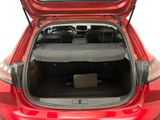 the back of a red car with its trunk open and luggage in the trunk