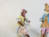 two figurines of a man and a woman with musical instruments