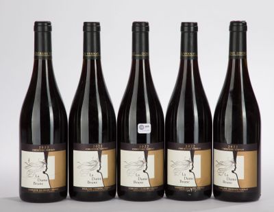 six bottles of wine are lined up on a white surface