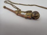 a brass pipe with a chain around it on a white surface