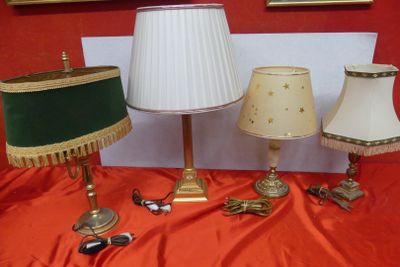 three lamps on a table with a red table cloth