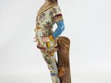 figurine of a man dressed in a suit and holding a sword