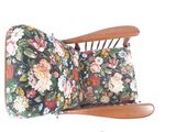 un fauteuil à bascule en bois sur lequel est posé un coussin à motifs floraux
