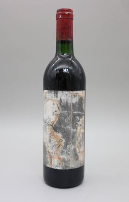 une vieille bouteille de vin rouge posée sur une table blanche