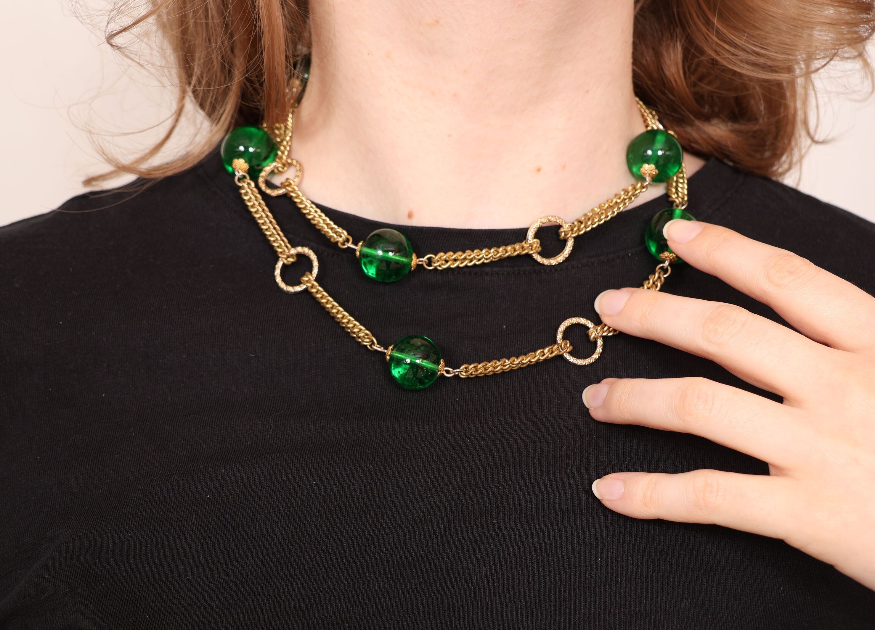 Collier fantaisie en métal doré alterné de perles de verre teintées vert et anneaux. Non signé. L_88 cm