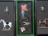 quatre figurines miniatures représentant des soldats et des chevaux, présentées dans une vitrine