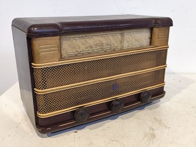 une vieille radio posée sur une table près d'un mur blanc