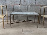 trois chaises et une table devant un mur en béton