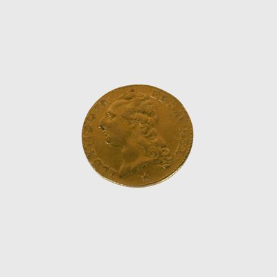 gros plan d'une pièce d'or sur une surface blanche
