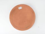 a brown plate on a white surface with a sticker on it