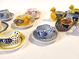 de nombreux types de tasses à thé et de soucoupes sur la table