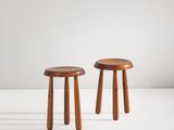 une paire de tabourets en bois posés sur une surface blanche
