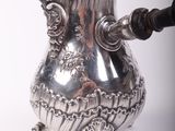 a silver coffee pot with a handle on a white background