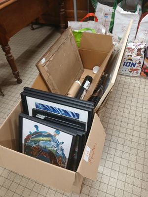 a cardboard box full of art supplies on the floor