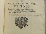 un livre ouvert sur lequel figure l'image d'un vase rempli de fleurs