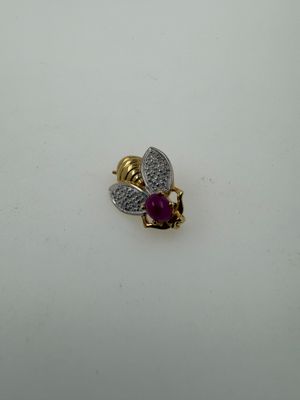 a close up of a gold and diamond bee brooch