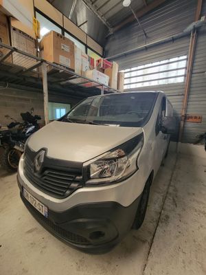 La camionnette blanche est garée dans le garage, à côté des motos.
