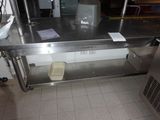 une table en acier inoxydable sur laquelle est posée une poubelle