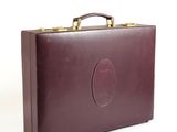 brown leather briefcase sitting on a white surface with a white background