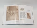 an open book with a picture of a woman wearing a diamond necklace