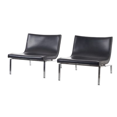 une paire de fauteuils de salon en cuir noir avec des pieds chromés