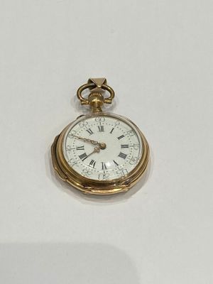 a gold pocket watch with roman numerals on it