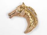 un gros plan d'une broche en forme de tête de cheval en or sertie de diamants
