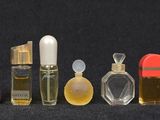 many different types of perfume bottles lined up on a black surface