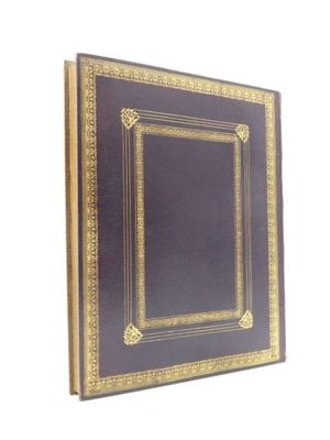 un vieux livre avec une bordure dorée sur fond blanc